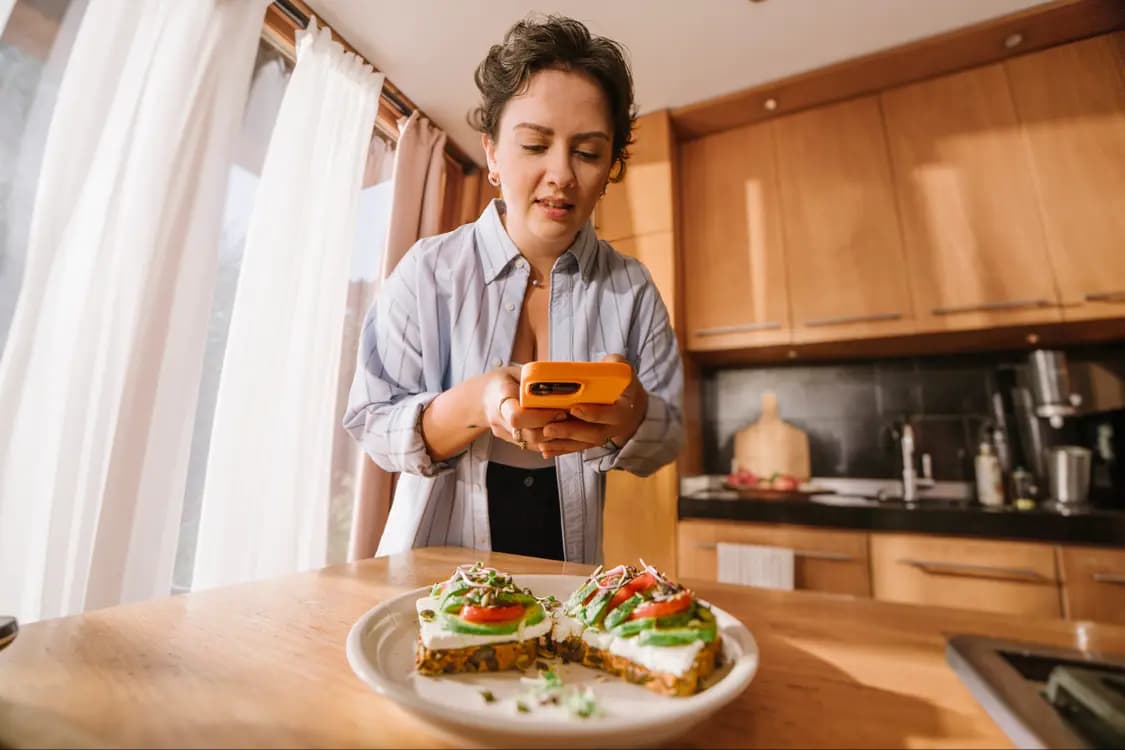 Frau fotografiert ihr Essen zur automatischen Kalorienberechnung